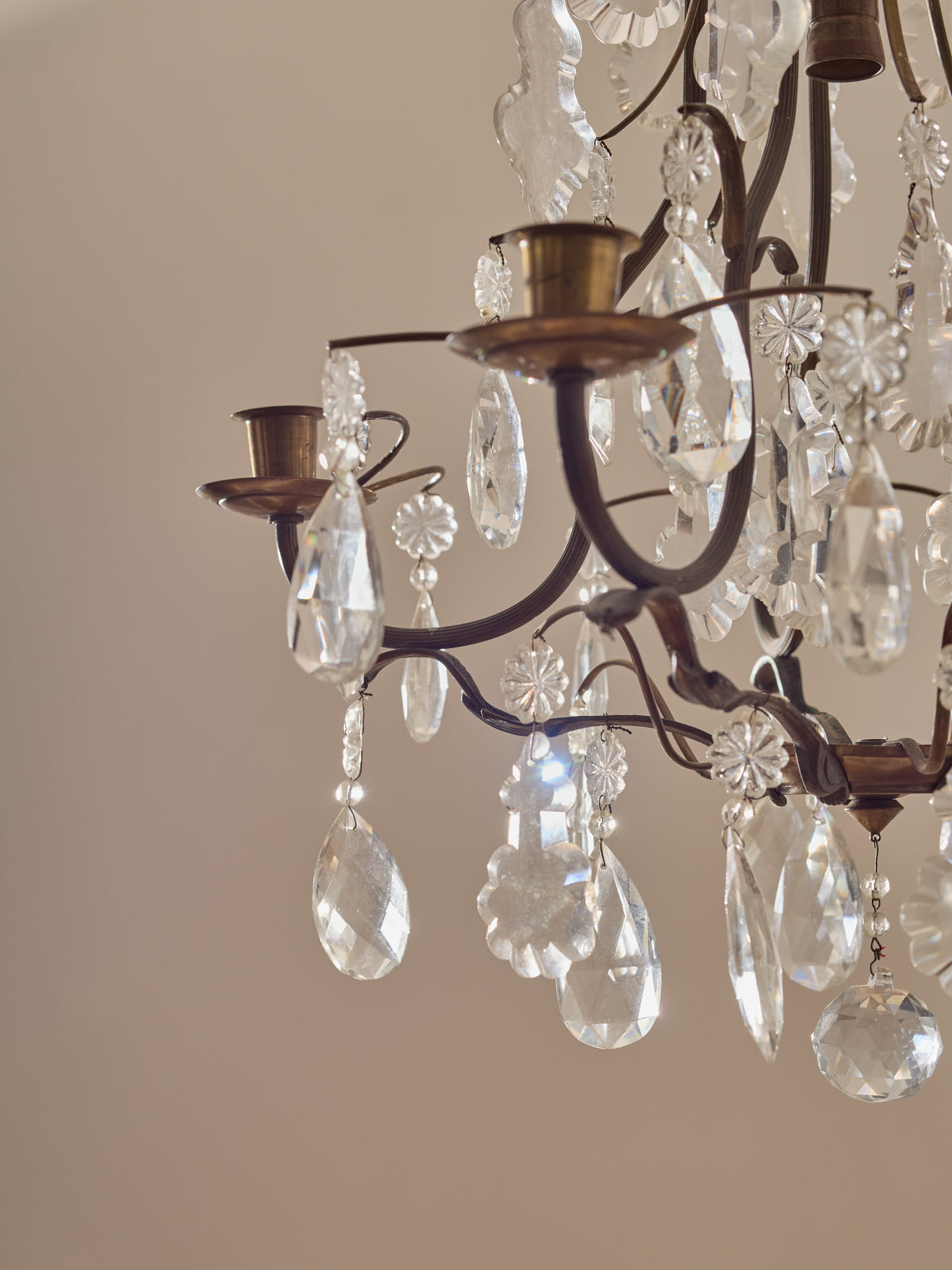 Close-up of a chandelier with crystal droplets against a neutral background