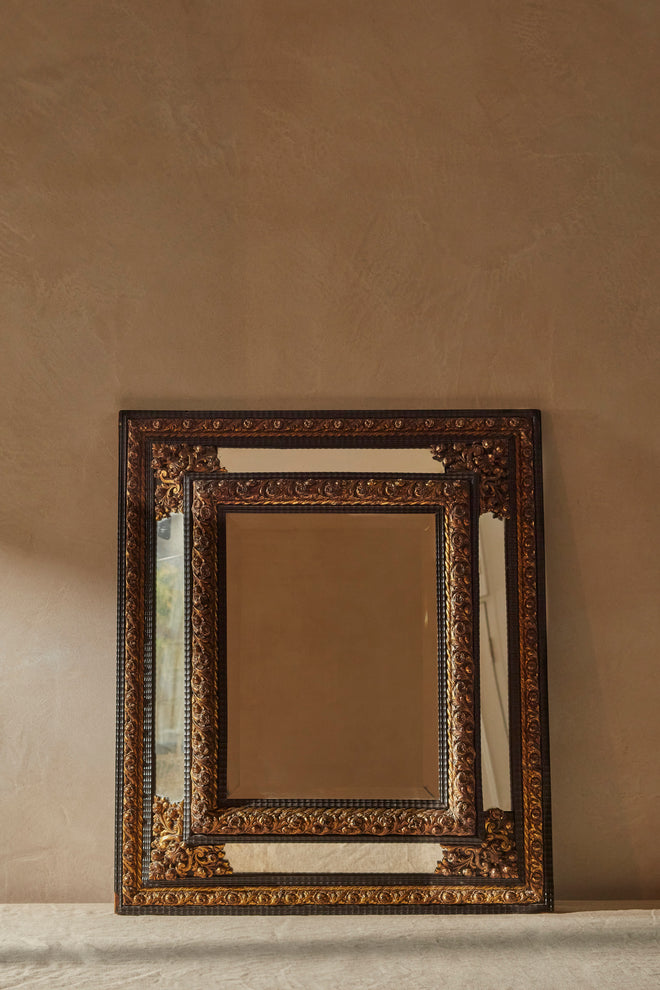A Northern European Brass and Ebonised cushion mirror