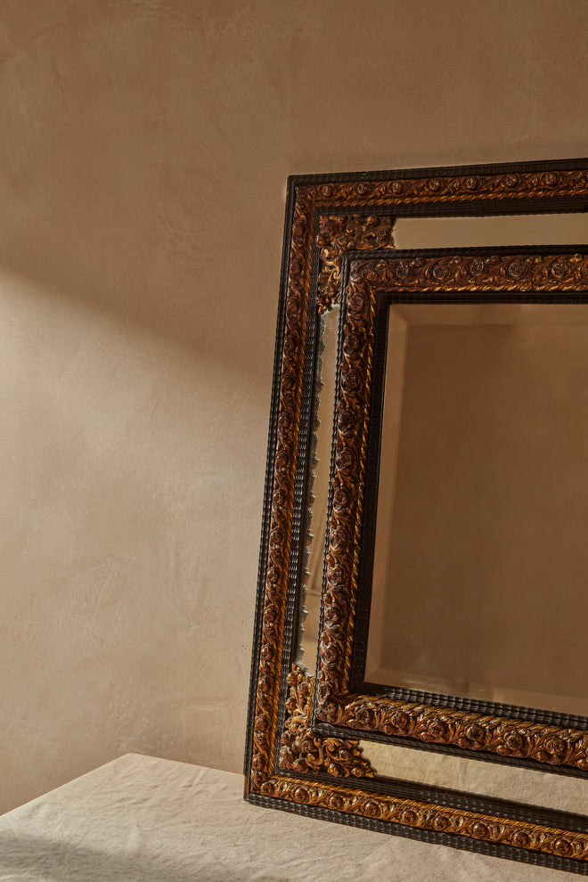 A Northern European Brass and Ebonised cushion mirror