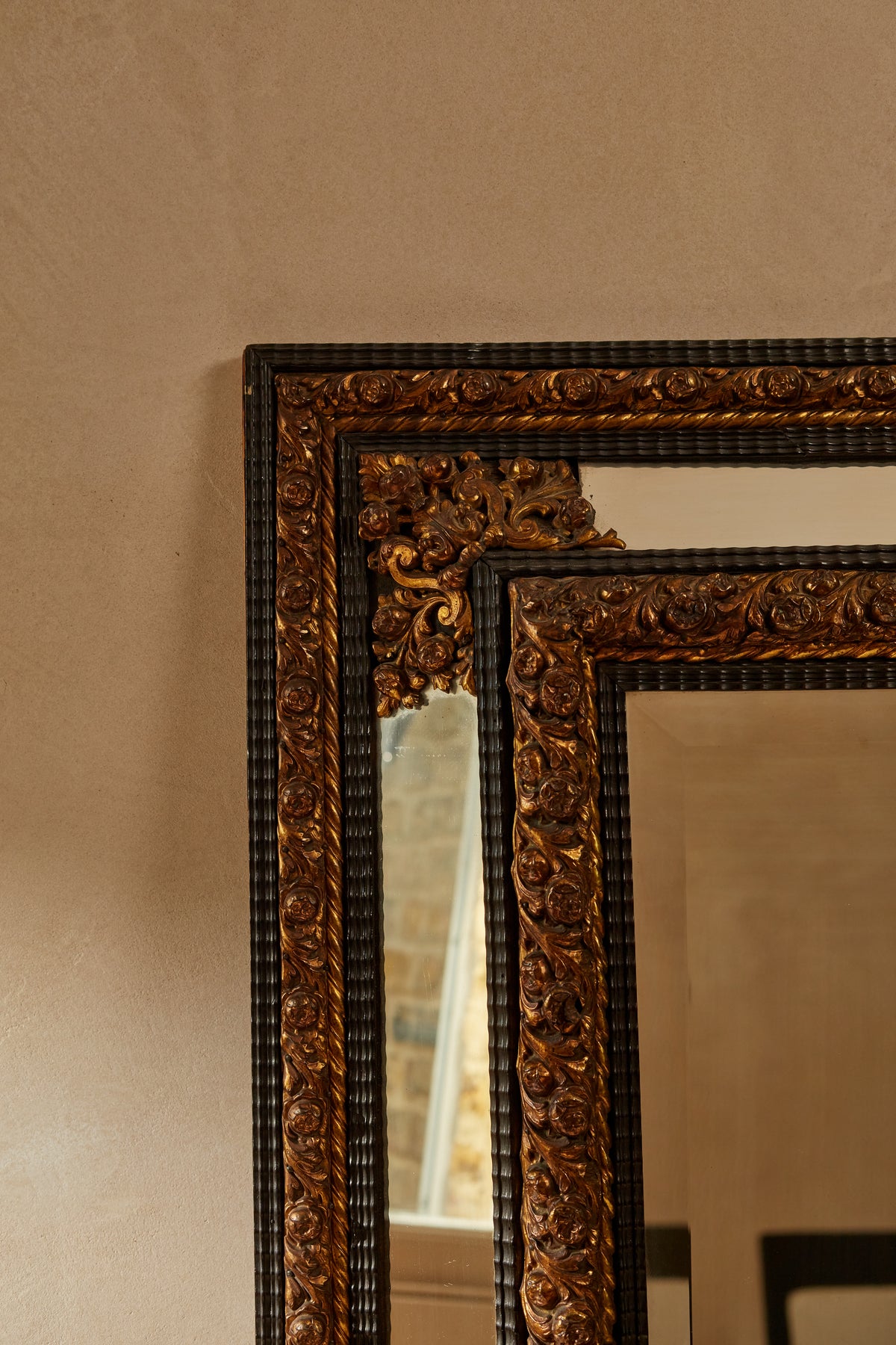 A Northern European Brass and Ebonised cushion mirror